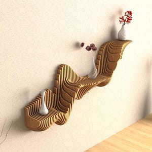 Puede incluir: Una estanter&iacute;a de pared de madera con un dise&ntilde;o ondulado. La estanter&iacute;a tiene tres niveles y est&aacute; decorada con jarrones blancos y flores.