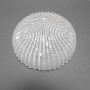 May include: A white, textured, semi-spherical glass light fitting. The fitting has a repeating wave pattern across its surface and a scalloped edge. The design is simple and elegant.