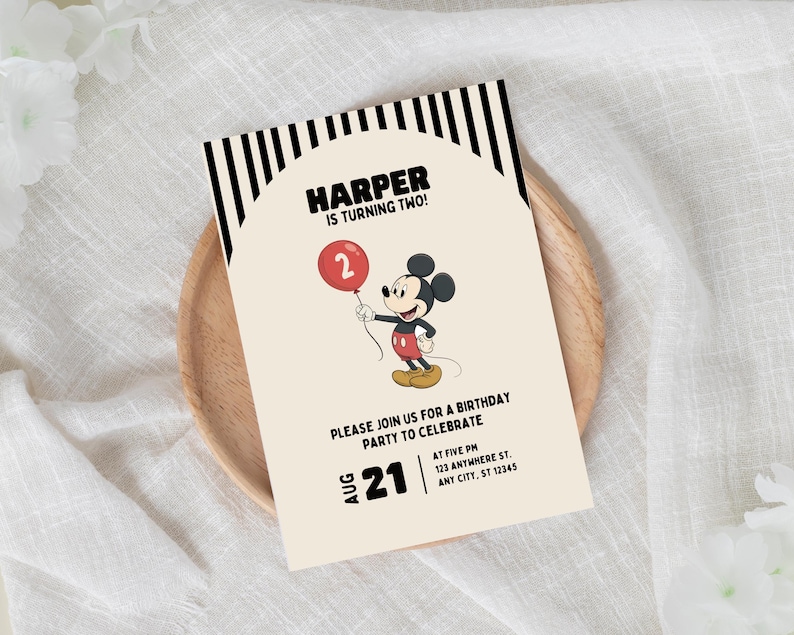 May include: A birthday invitation featuring Mickey Mouse holding a red balloon with the number 2. The invitation has the text "HARPER IS TURNING TWO!" and details for the party, including the date, time, and address. The invitation is on a wooden plate.