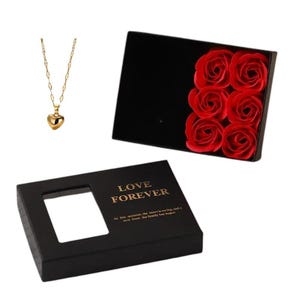 Pu&ograve; includere: Una scatola regalo nera con un'iscrizione dorata che recita "Love Forever" e una finestra trasparente per vedere il contenuto. La scatola contiene una collana a forma di cuore d'oro e una scatola di rose rosse.