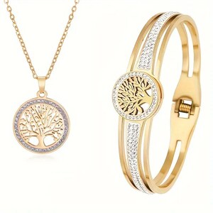 May include: A gold-tone necklace and bracelet set featuring a tree of life pendant and matching bracelet with clear crystal accents.