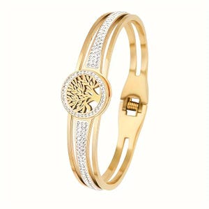 May include: Gold-tone bangle bracelet with a tree of life design and clear crystal accents.