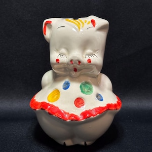 Puede incluir: Una taza de cerámica blanca con un asa negra y el texto "But First, Coffee" en negro, con una fuente de estilo manuscrito. La taza está sobre una superficie blanca.