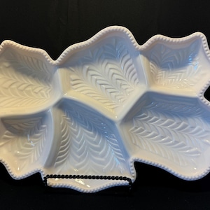 May include: A white ceramic serving dish with five sections. The dish has a leaf design and a beaded edge.