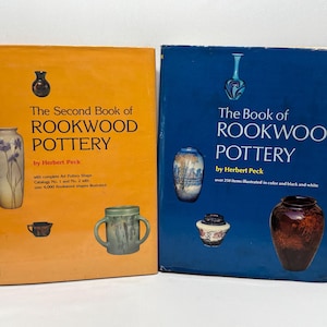 May include: Two hardcover books titled "The Second Book of Rookwood Pottery" and "The Book of Rookwood Pottery" by Herbert Peck. The books feature images of Rookwood pottery on their covers, with an orange and blue background.