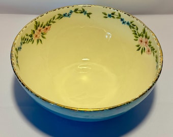 May include: A blue and white ceramic bowl with a floral design. The bowl has a gold rim and a light blue base.