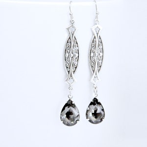 May include: Silver filigree dangle earrings with teardrop shaped black crystal stones.