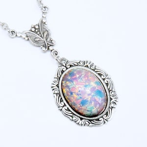 May include: A silver necklace with an iridescent opal pendant set in an ornate silver frame.