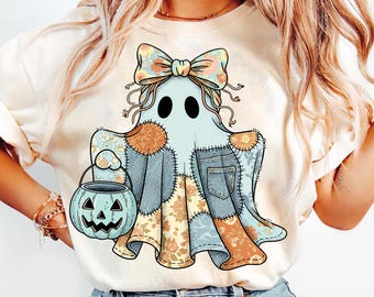 Könnte beinhalten: Hellfarbenes T-Shirt mit einem Cartoon-Geist-Design. Der Geist ist hellblau mit Patchwork-Details, einer floralen Schleife und einem kürbisförmigen Süßigkeiteneimer. Das Design beinhaltet Jeansstoff und florale Muster, ideal für Halloween.