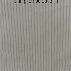 May include: Close-up of a fabric with vertical stripes in beige and white. The text "Lining: Stripe Option 1" is displayed in black at the top of the image. The fabric has a subtle texture.