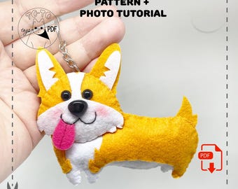 May include: A handmade felt corgi dog keychain with a yellow and white body, black eyes, and a pink tongue. The keychain has a metal ring and the text "PATTERN + PHOTO TUTORIAL".