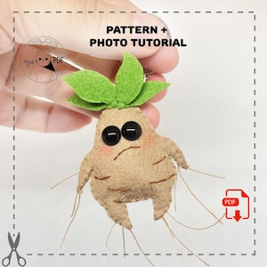 Pode incluir: Boneca de feltro de Mandrágora com uma parte superior verde folhosa, olhos de botão pretos e um corpo castanho claro. A boneca tem um aspeto envelhecido com blush nas bochechas e raízes castanhas finas. O texto na imagem diz "PATTERN + PHOTO TUTORIAL".