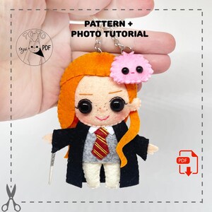 May include: A felt keychain depicting a character with orange hair, a black robe, and a red and gold striped tie. The keychain includes a pink, fluffy creature and the text "PATTERN + PHOTO TUTORIAL".