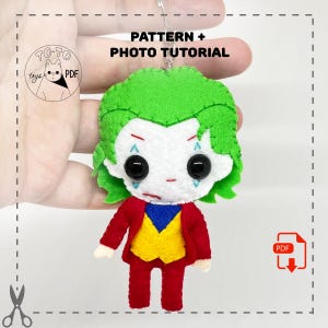 May include: A felt toy keychain of the Joker from Batman. The Joker is wearing a red suit with a yellow vest and a blue shirt. He has green hair and a white face with a red smile and black eyes. The keychain is labeled "PATTERN + PHOTO TUTORIAL".