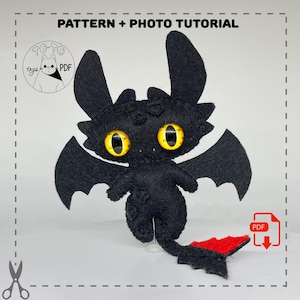May include: A handmade black felt dragon plush with large yellow eyes, wings, and a red tail fin. The image includes the text "PATTERN + PHOTO TUTORIAL" and a PDF download icon, suggesting a craft project.