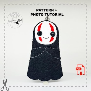 May include: A handmade black felt No-Face plushie with a white face, red accents, and black button eyes. The plushie has a silver keychain and is a PDF pattern with a photo tutorial. The text "PATTERN + PHOTO TUTORIAL" is above the plushie.