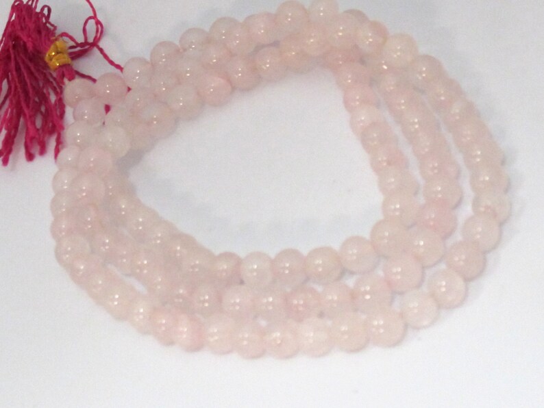 Pu&ograve; includere: Fili di perline di quarzo rosa pallido. Le perline sono rotonde e lisce, che formano pi&ugrave; fili. Un nappa rosa con accenti dorati &egrave; attaccata alla parte superiore dei fili.