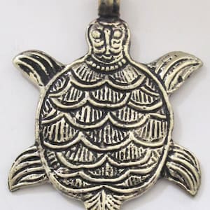 May include: A detailed, antique-style turtle pendant with a textured surface. The pendant is made of a metallic material, featuring a head, four flipper-like limbs, and a shell with intricate patterns. It has a loop at the top for a chain.