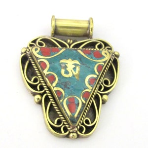 May include: A brass-colored pendant with a turquoise triangle center featuring a gold symbol. The triangle is bordered by red accents and a gold filigree design. A brass loop is at the top.