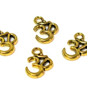 May include: Four small, gold-colored Om symbol charms. Each charm features the Om symbol with a loop at the top for stringing. The charms are on a white background.