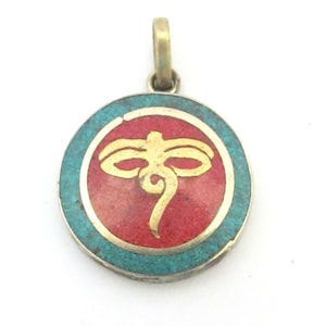 May include: Round pendant with a gold-colored bail. The pendant features a red center with a gold-colored symbol, surrounded by a turquoise border. The pendant is made of metal.