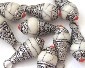 May include: A collection of ivory-colored, teardrop-shaped beads with silver-colored metal accents. Each bead features a red accent at the tip and a small loop for stringing. The beads have a cracked, textured appearance.