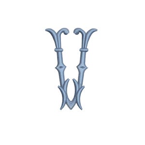 May include: A light blue embroidered letter "V" with a decorative, ornate design. The letter features a stylized, symmetrical shape with curved top elements and a pointed base. The embroidery has a textured appearance against a white background.