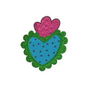 May include: An embroidered heart design with a blue center, dotted with small brown seeds, and a green scalloped border. Above the heart is a pink, textured shape. The design is on a white background.