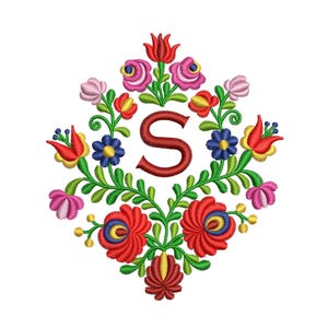 以下が含まれることがあります： 赤い文字「S」が中央に置かれた刺繍された花のデザイン。花は赤、ピンク、黄色、青、緑の色合いです。