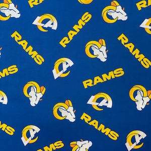 May include: A blue fabric with a repeating pattern of yellow "RAMS" text and the Los Angeles Rams logo, which includes a ram's head and the letters "LA" in a circle.