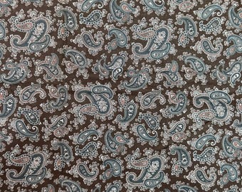 May include: Brown fabric with a repeating paisley pattern. The paisley designs feature shades of blue, white, and pink, creating a detailed and textured appearance. The fabric has a classic, vintage aesthetic.