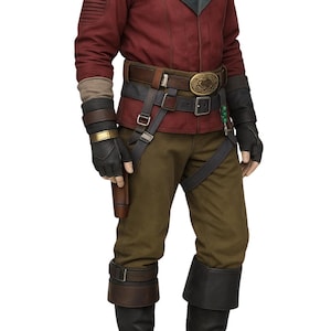 May include: A detailed costume featuring a burgundy jacket with a green collar, brown pants, and black boots. The outfit includes multiple belts, a holster, and gloves. A decorative necklace and a gold buckle add detail to the ensemble.