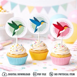 May include: Three cupcakes with white frosting and colorful sprinkles. Each cupcake has a different colored liner: blue, yellow, and pink. Each cupcake is topped with a round hummingbird design on a stick. The image includes the text "DIGITAL DOWNLOAD", "PDF FILE", and "NO PHYSICAL ITEM".