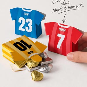 Puede incluir: Tres cajas de papel con forma de camiseta en azul, rojo y amarillo con rayas blancas, nombres y números. La caja amarilla está abierta, revelando chocolates envueltos en papel dorado y plateado. Texto: Customize your name & number, Digital Download, PDF File, No physical item.