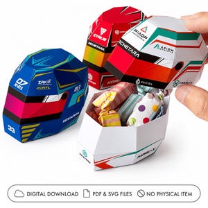 Könnte beinhalten: Drei Papier-Bastelboxen in Form von Rennhelmen mit geometrischen Mustern. Eine ist blau mit roten und gelben Akzenten, eine ist rot mit weißen Details und eine ist weiß mit grünen und roten Streifen, gefüllt mit kleinen eingewickelten Bonbons.