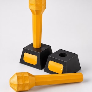 May include: Two yellow papercraft microphones with textured heads and smooth handles. One microphone stands upright on a black trapezoidal base with a yellow plaque, while the other lies horizontally. A separate black base with a yellow plaque is included.
