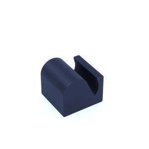 Puede incluir: Un soporte para teléfono de plástico negro con un diseño curvo. El soporte tiene una ranura para sujetar un teléfono.