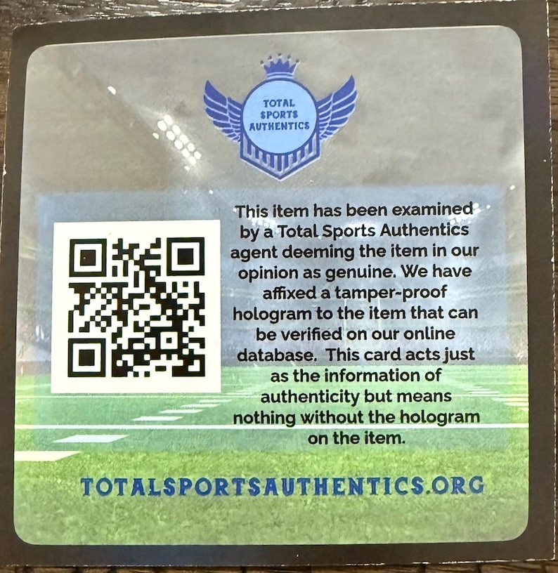 Puede incluir: Una tarjeta rectangular con un c&oacute;digo QR y texto de Total Sports Authentics. El texto indica que el art&iacute;culo ha sido examinado y considerado genuino, con un holograma a prueba de manipulaciones para verificaci&oacute;n en su base de datos en l&iacute;nea.