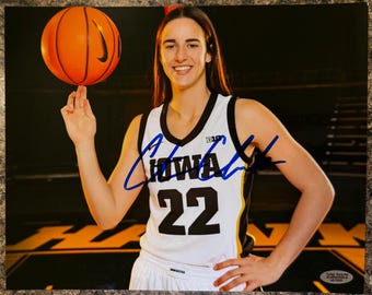 May include: A glossy photograph featuring a basketball player in a white Iowa jersey with the number 22, spinning an orange basketball on one finger. The image includes a blue ink autograph across the center and a Total Sports Authentics sticker.