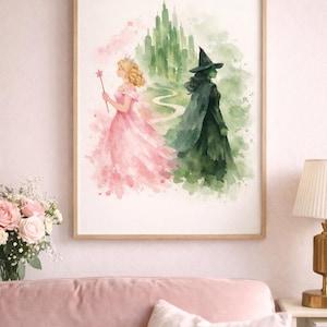 May include: Watercolor print in a wooden frame featuring two figures from The Wizard of Oz. One figure is a princess in a pink dress, holding a star wand. The other is a green-skinned witch in a black dress and hat, with a green background.