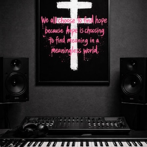 May include: Black framed artwork with a white cross and pink text that reads "We all choose to find hope because hope is choosing to find meaning in a meaningless world." The image is in a studio setting with speakers, a mixing board, and a keyboard.