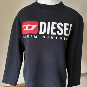 May include: Black long-sleeve sweatshirt with a white "Diesel Denim Division" logo and a red Diesel logo.