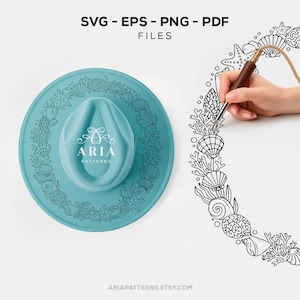 May include: A teal-colored hat with a seashell design and the text "ARIA PATTERNS". The image also features the text "SVG - EPS - PNG - PDF FILES" and "ARIAPATTERNS.ETSY.COM". A hand is drawing a seashell border.