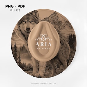 May include: A tan fedora hat with the text "ARIA PATTERNS" is centered over a circular design featuring a wolf, mountains, and trees. The words "PNG - PDF FILES" are at the top. The website address is at the bottom.