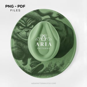 May include: A green round design featuring a cartoon character and a green oval-shaped object with the text "ARIA PATTERNS". The words "PNG - PDF FILES" are at the top. The website address "ARIAPATTERNS.ETSY.COM" is at the bottom.