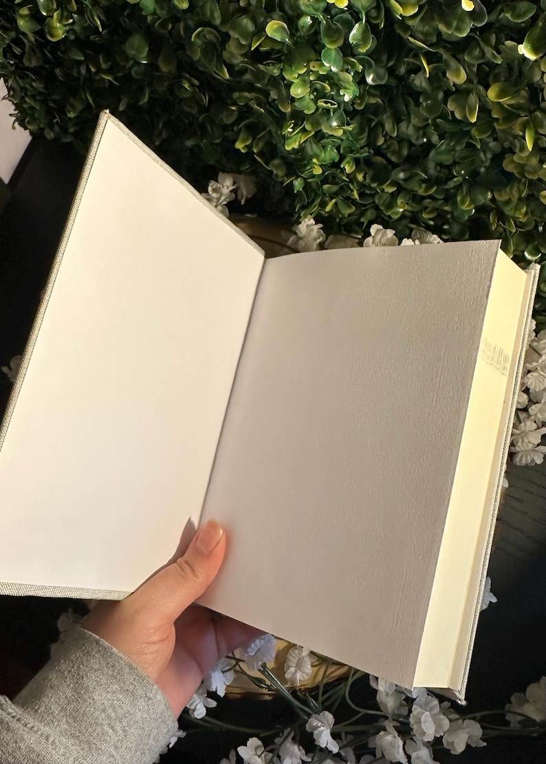 Op de afbeelding: Een blanco, wit, met linnen bekleed dagboek met een cr&egrave;mekleurige binnenkant. Het dagboek is open om de lege pagina's te laten zien.