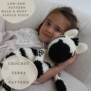 May include: A black and white striped crocheted zebra toy is held by a child. The toy has a round head and a long body. The image includes text that reads "LOW-SEW PATTERN HEAD & BODY - SINGLE PIECE" and "CROCHET ZEBRA PATTERN."
