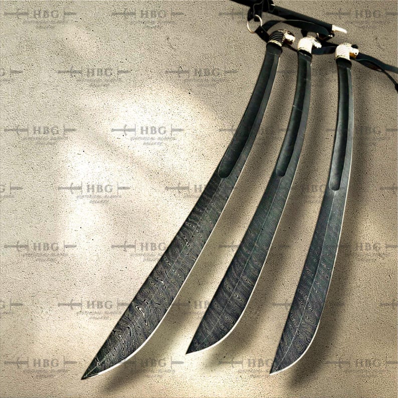 K&ouml;nnte beinhalten: Drei schwarze Schwerter mit komplizierten Mustern auf den Klingen. Die Schwerter sind f&auml;cherf&ouml;rmig auf einem hellbraunen Hintergrund angeordnet.
