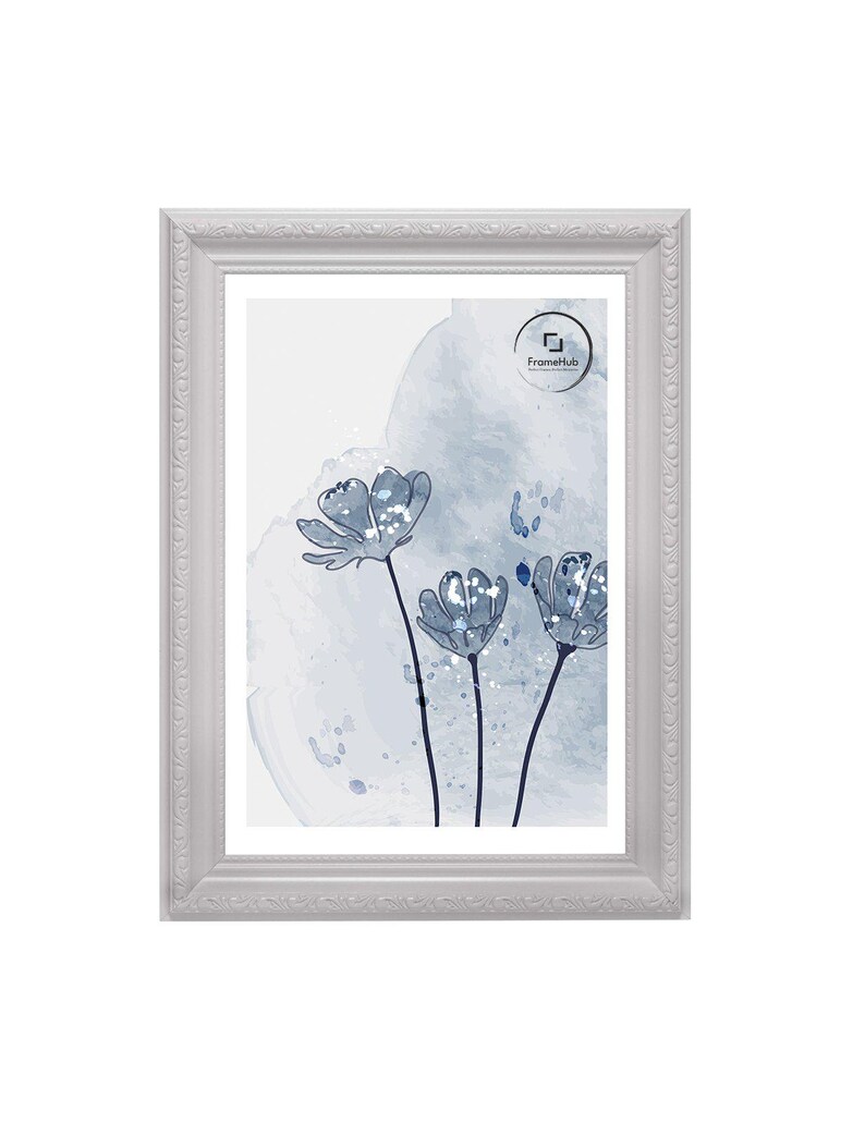 May include: A rectangular white picture frame with ornate detailing surrounds a print of blue watercolor flowers. The artwork features three stylized flowers with dark stems against a light blue and white background. The FrameHub logo is visible.