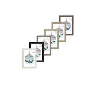 May include: Set of six picture frames in various wood tones, each featuring a fern leaf design and a white label with the word "Nature" printed on it. The frames are arranged in a row, with the largest frame at the top and the smallest frame at the bottom.